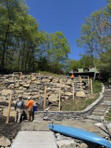 Excavation to create a terraced vineyard in backyard using stones found onsite adjacent to natural bluestone stairway coming from the backyard to the lake.