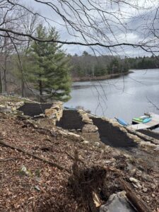 Side view of excavation to create a terraced vineyard in backyard using stones found onsite adjacent to natural bluestone stairway coming from the backyard to the lake.